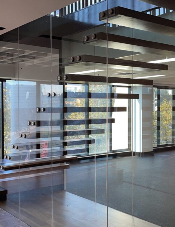 Office fit-out with glass partitions and a floating timber stair